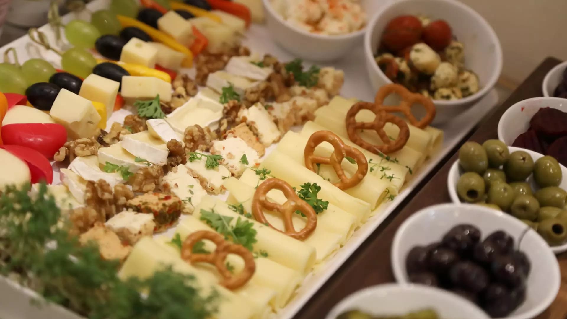 Käseplatte mit Brezeln, Oliven, Weintrauben und Walnüssen als Frühstücksauswahl