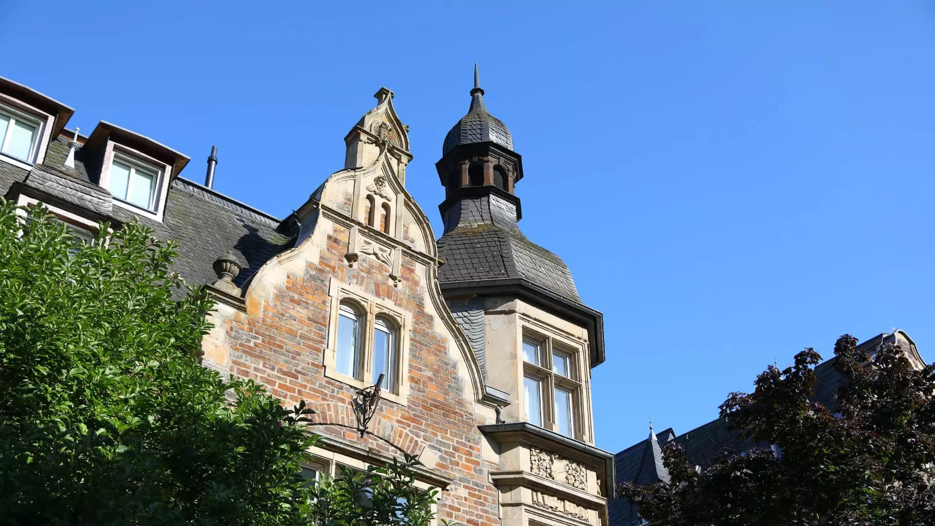 Giebel und Türmchen der Moselvilla im Detail vor blauem Himmel